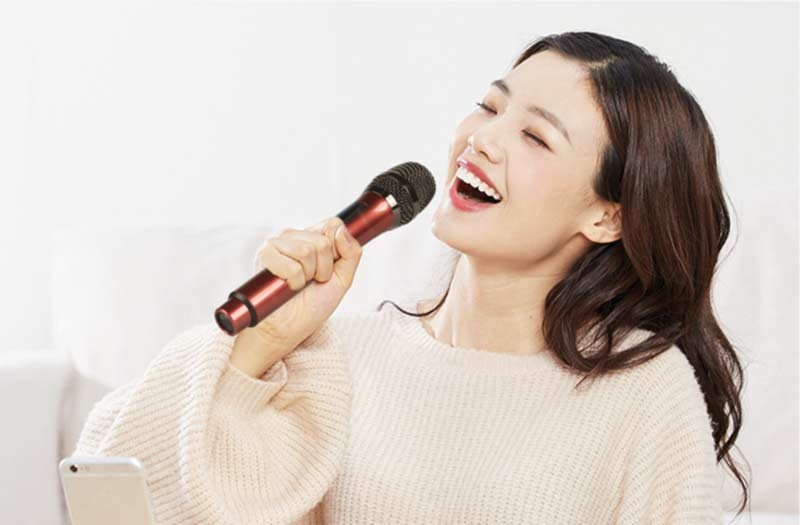 Gia đình vui vẻ hát karaoke với micro không dây bluetooth hiện đại