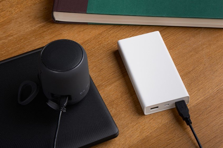 Người dùng đang sạc và nghe nhạc trên loa bluetooth