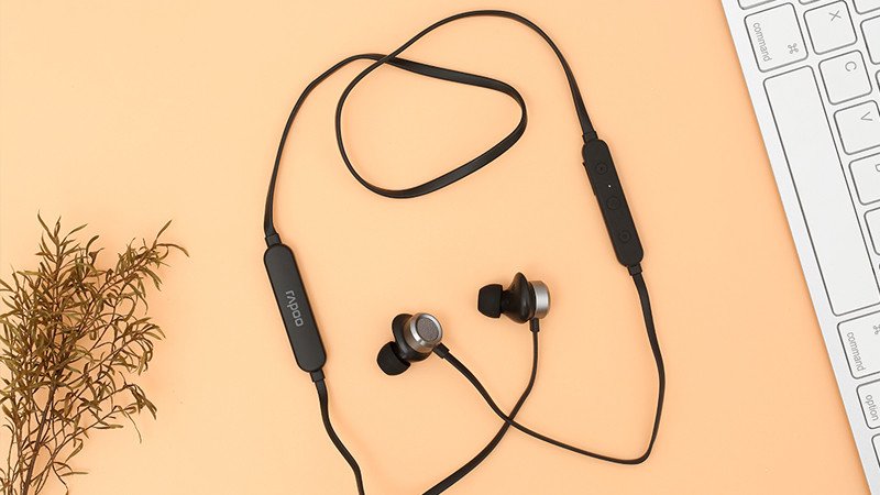 Cận cảnh tay người đang kiểm tra dây cáp của một chiếc tai nghe Bluetooth có dây nối, nhấn mạnh tầm quan trọng của việc kiểm tra dây cáp khi kết nối tai nghe Bluetooth với điện thoại Samsung.