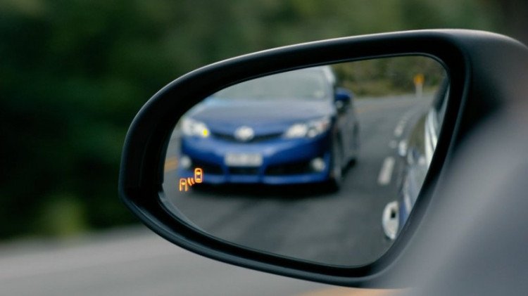 Cảnh một chiếc ô tô đang vượt một chiếc xe tải khác trên đường quốc lộ, minh họa tình huống giao thông cần sự chú ý cao.