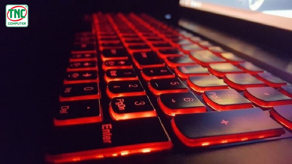 Cảnh một người dùng đang sử dụng laptop trong phòng tối, thể hiện lợi ích của việc có đèn bàn phím laptop để dễ dàng thao tác, bảo vệ mắt.