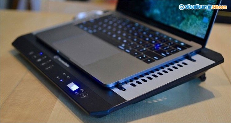 Đế tản nhiệt chuyên dụng với quạt làm mát đang làm việc dưới laptop gaming, hỗ trợ giảm nhiệt độ laptop