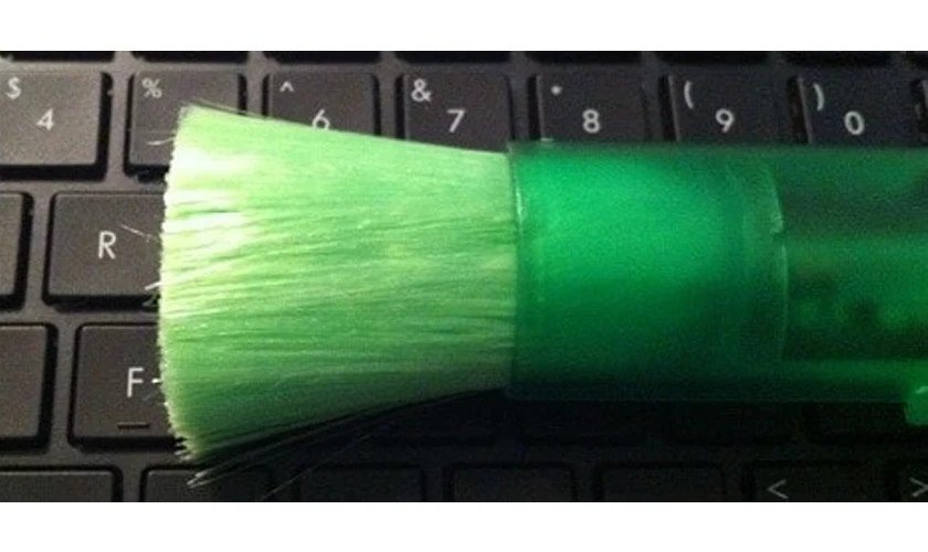 Dùng cọ mềm loại bỏ bụi bẩn giữa các phím khi vệ sinh bàn phím laptop Dell.