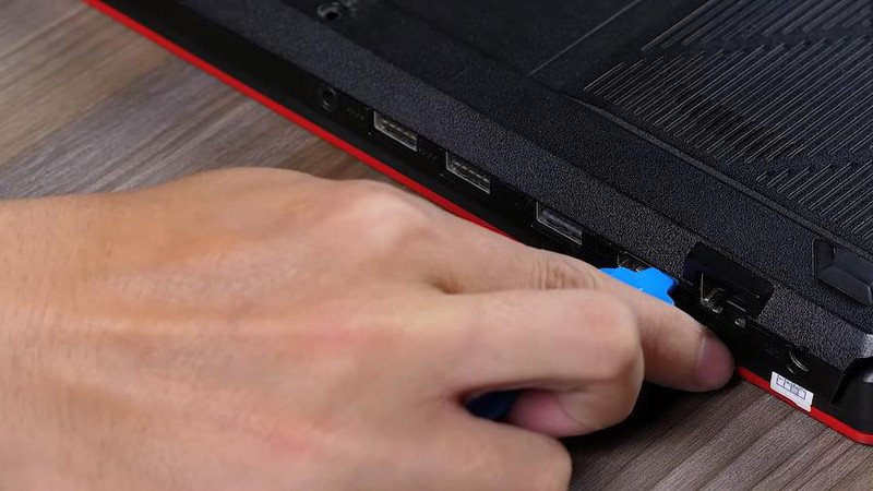 Dùng dụng cụ mỏng để tách nhẹ vỏ máy laptop ra khỏi thân