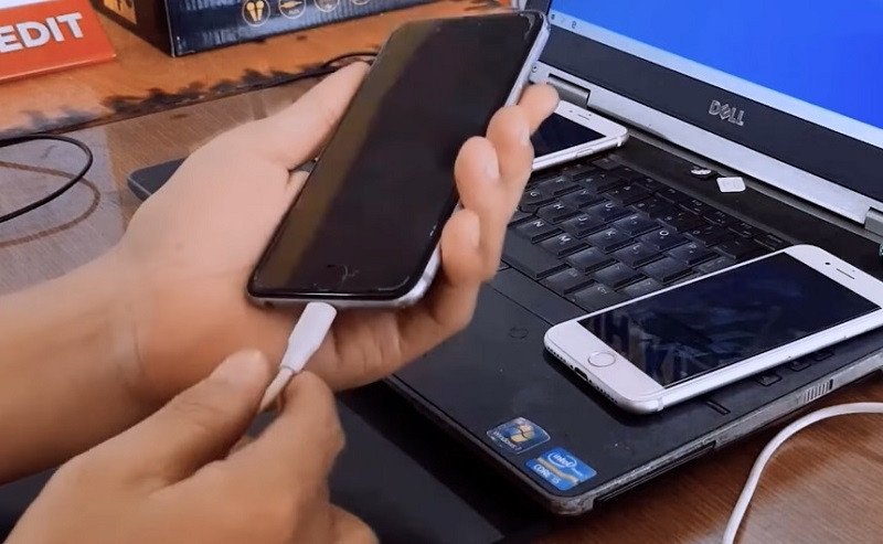 Hình ảnh bàn tay cắm tai nghe Lightning vào cổng sạc của iPhone