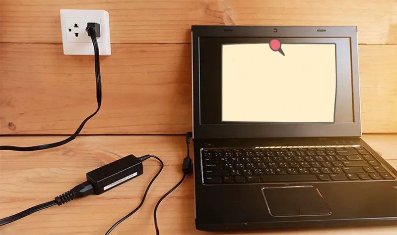 Hình ảnh laptop cắm sạc và biểu tượng sạc pin trên màn hình