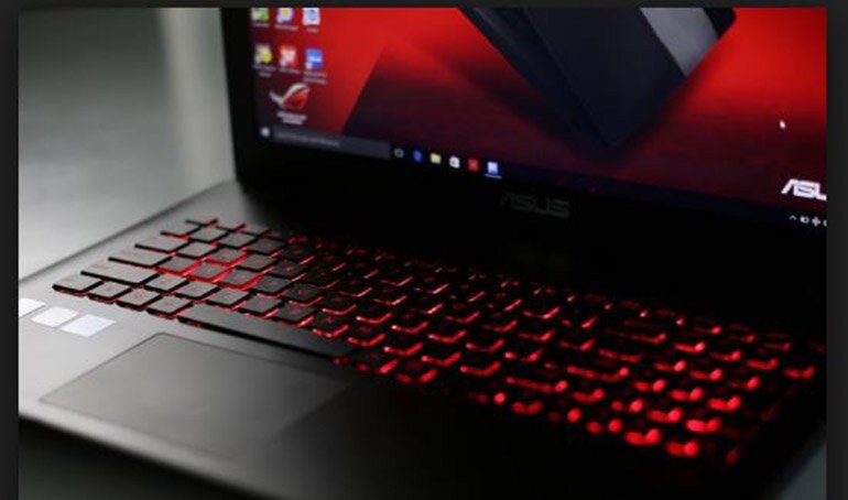 hình ảnh minh họa người dùng đang vừa sạc vừa dùng laptop Asus trên bàn làm việc