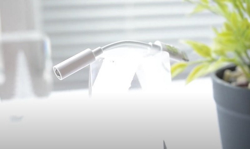 Hình ảnh một chiếc iPhone đang kết nối với tai nghe qua bộ chuyển đổi Lightning