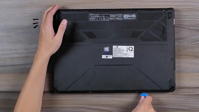 Kéo dọc theo đường viền giữa nắp khớp với thân máy để mở
