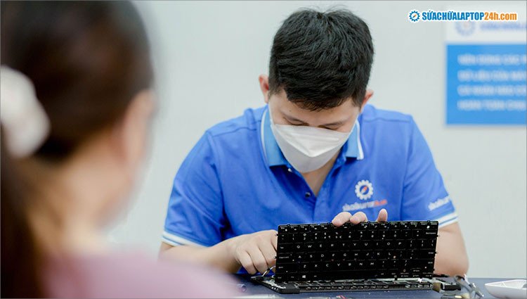 Khách hàng quan sát kỹ thuật viên thực hiện quy trình sửa chữa laptop 24h TPHCM công khai