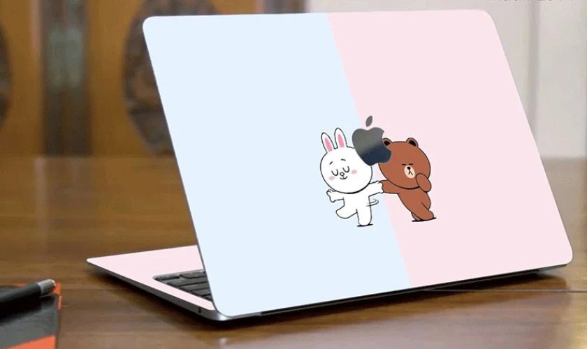 Kỹ thuật viên đang dán skin lên laptop một cách tỉ mỉ và chuyên nghiệp