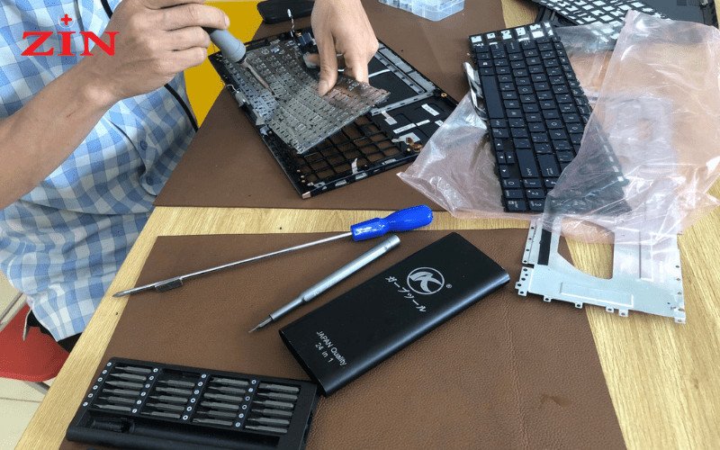 Kỹ thuật viên đang hoàn tất việc thay bàn phím laptop Asus và kiểm tra lần cuối