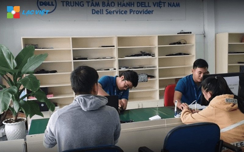 Kỹ thuật viên đang kiểm tra bên trong một chiếc laptop Dell, chuẩn bị cho việc thay RAM
