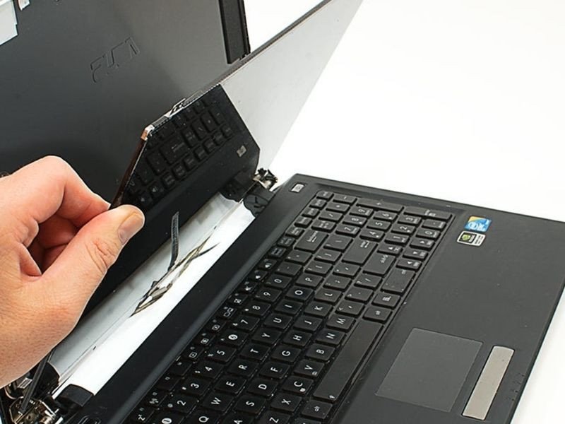 Kỹ thuật viên đang kiểm tra màn hình laptop sau khi thay thế, đảm bảo chất lượng hiển thị và hoạt động ổn định