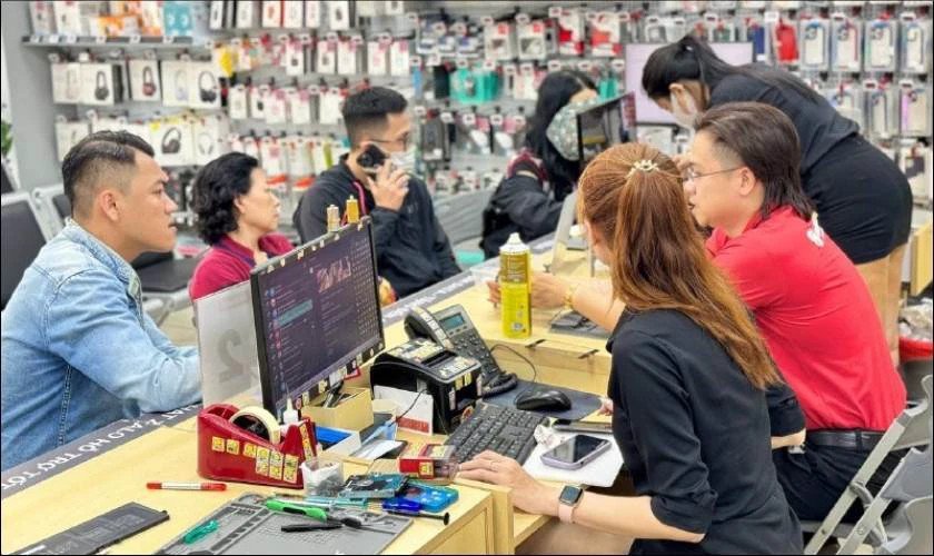 Kỹ thuật viên đang kiểm tra thông số kỹ thuật của laptop để xác định loại sạc phù hợp, giúp bạn biết sạc laptop bao nhiêu w cần thiết.