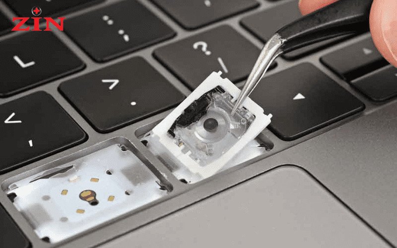 Kỹ thuật viên đang tháo lắp bàn phím laptop Asus một cách cẩn thận