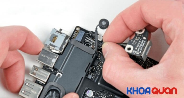 Kỹ thuật viên đang thay thế nút nguồn laptop bị liệt.