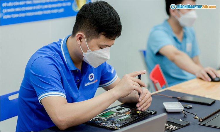 Kỹ thuật viên đang thực hiện thay thế quạt tản nhiệt cho laptop một cách cẩn thận