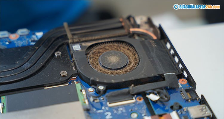 Kỹ thuật viên đang vệ sinh quạt tản nhiệt của laptop, loại bỏ bụi bẩn để làm mát laptop khi chơi game