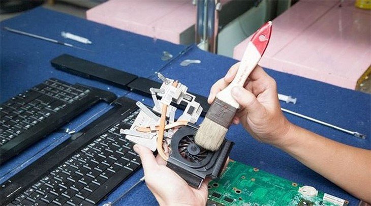 Kỹ thuật viên đang vệ sinh và thay keo tản nhiệt cho laptop