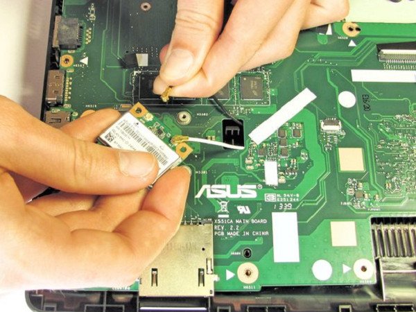 kỹ thuật viên kiểm tra card wifi bên trong laptop