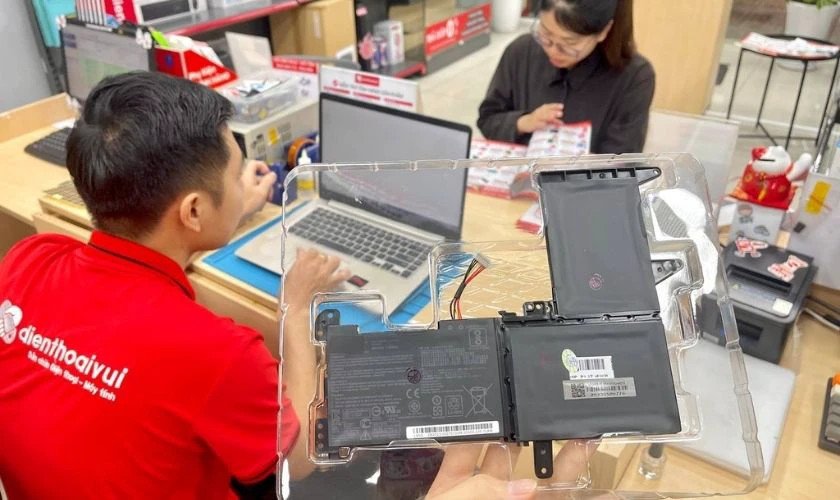 kỹ thuật viên kiểm tra pin laptop tại trung tâm sửa chữa