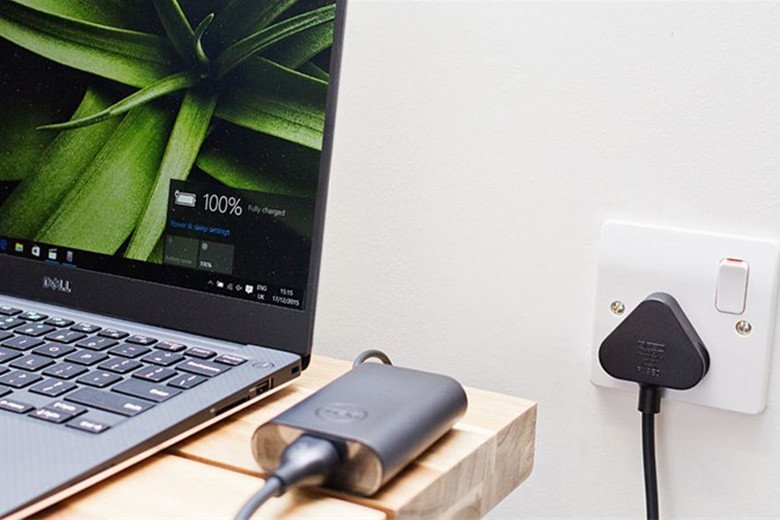 Laptop đang cắm sạc và đặt trên giá đỡ để tối ưu hóa pin laptop khi làm việc cường độ cao