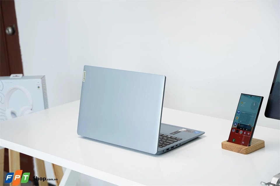 Laptop Lenovo Ideapad 3 15IAU7 màu xám đặt trên bàn làm việc, thể hiện thiết kế hiện đại và webcam thông minh hỗ trợ giáo viên dạy học trực tuyến hiệu quả