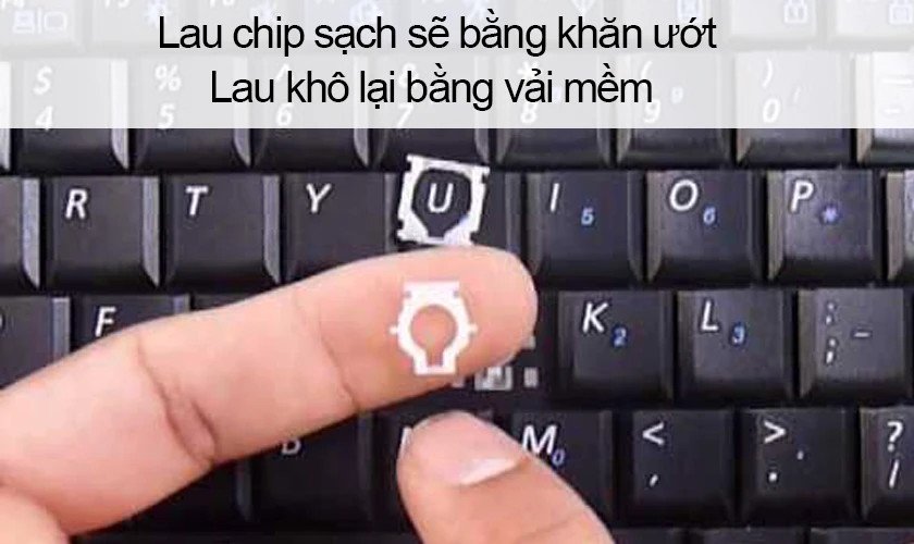 Lau sạch khu vực tiếp xúc và bo mạch dưới bàn phím sau khi tháo laptop Dell.