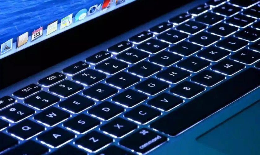 Mô tả đèn LED bàn phím laptop đang phát sáng trong môi trường tối, làm nổi bật các phím bấm.