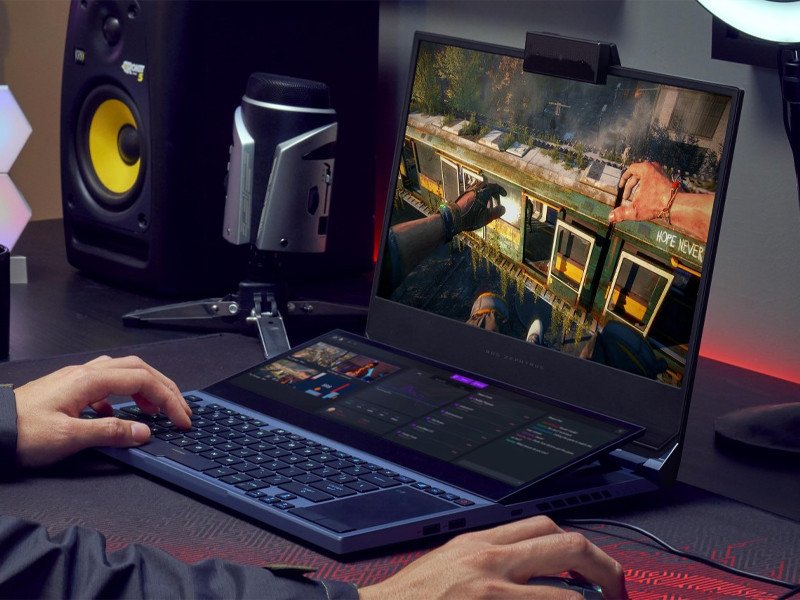 Một người đang chơi game trên laptop đã được cắm sạc