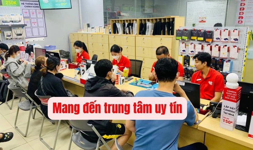 Một người dùng đang lau sạch bụi trên bàn phím laptop Lenovo