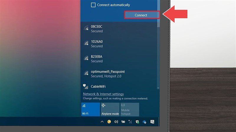 Một người phụ nữ đang thao tác trên laptop, hiển thị màn hình nền Windows với biểu tượng Wi-Fi bị lỗi