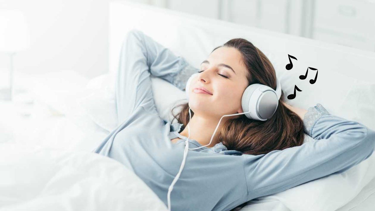Một người phụ nữ nằm ngủ yên bình trên giường với tai nghe chụp tai, thể hiện thói quen đeo tai nghe khi ngủ có sao không.