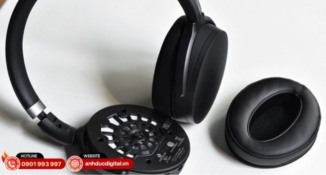 Người đàn ông đang đọc sách với tai nghe cách âm, biểu tượng cho sự tĩnh lặng