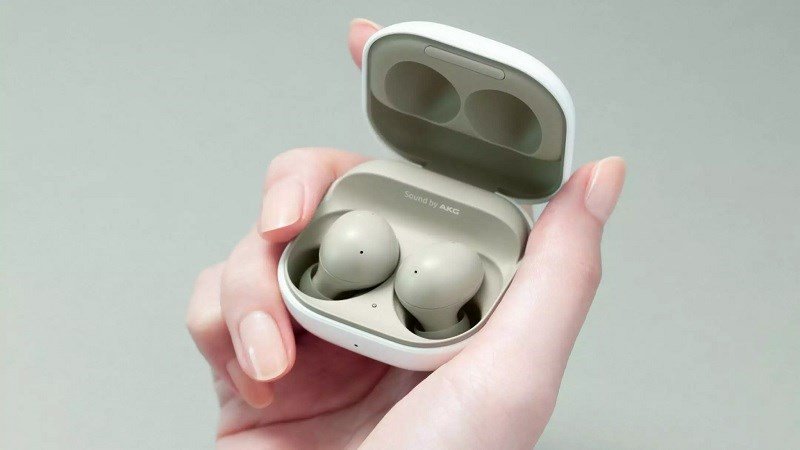 Người dùng đang cầm một chiếc tai nghe Bluetooth để chuẩn bị thực hiện cách reset tai nghe