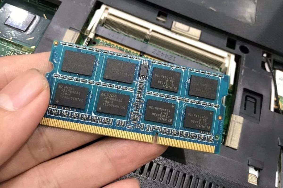 Người dùng đang lắp đặt RAM vào bo mạch chủ của laptop Dell, minh họa cho việc nâng cấp RAM