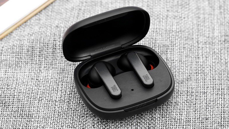 Người dùng đang nhấn giữ nút tăng giảm âm lượng trên tai nghe JBL để khôi phục cài đặt tai nghe