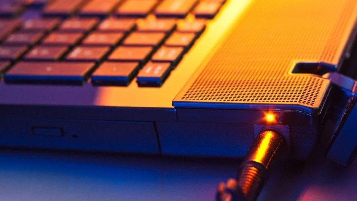 Người dùng đang nhìn vào đèn trạng thái sạc trên laptop Dell đang nhấp nháy màu vàng