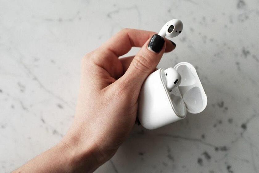Người dùng đang thao tác reset tai nghe Bluetooth để khắc phục lỗi nháy đèn xanh đỏ liên tục.