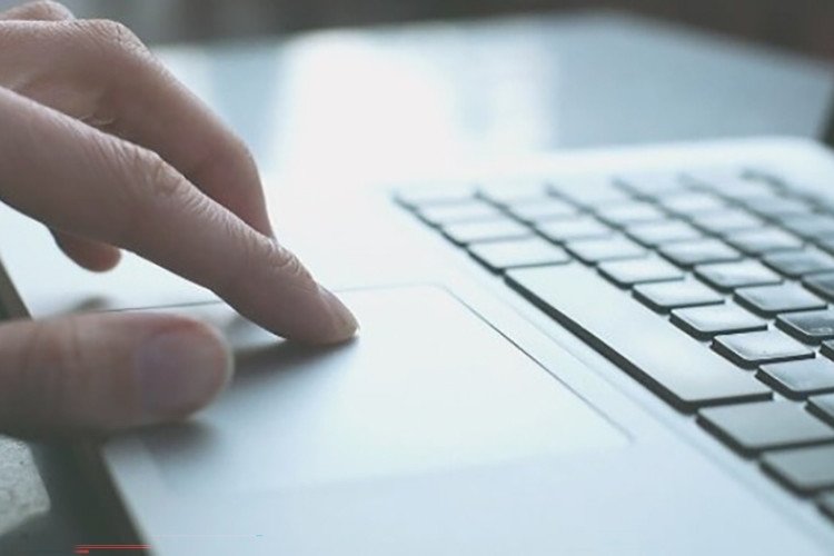 Người dùng đang thao tác trên bàn di chuột của laptop khi bị mất chuột cảm ứng