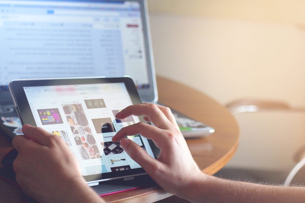 Người dùng di chuyển với iPad gọn nhẹ, thể hiện tính di động vượt trội của máy tính bảng khi làm việc từ xa.