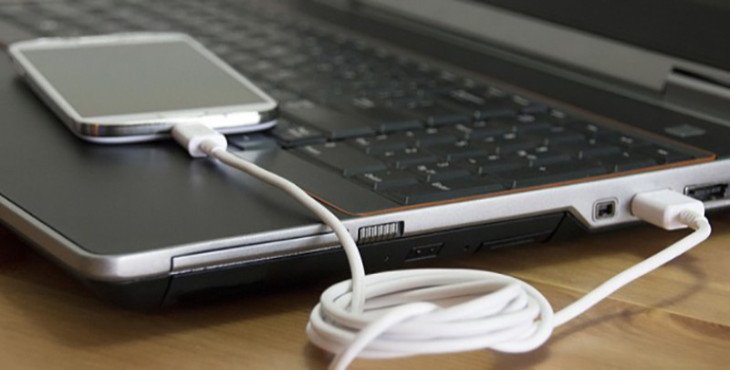 Người dùng kết nối điện thoại với laptop qua cáp USB để sạc pin đt bằng laptop