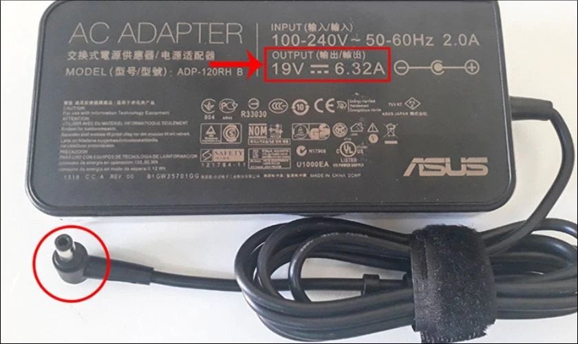 Người dùng kiểm tra thông số kỹ thuật trên adapter sạc laptop cũ