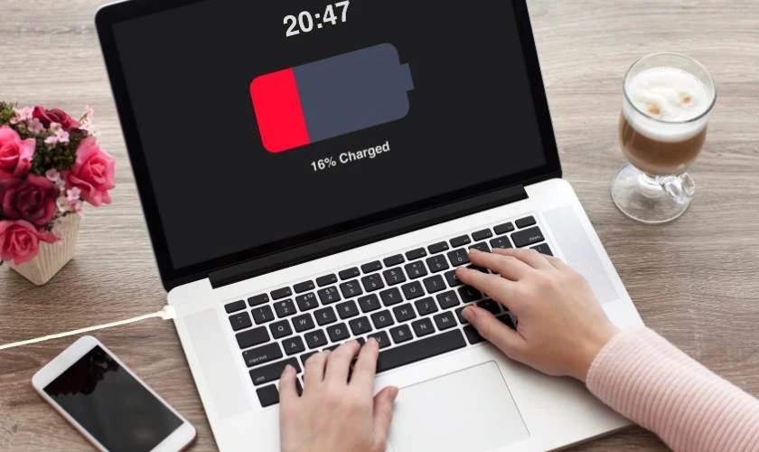 Người dùng làm việc trên laptop đang sạc, minh họa thói quen "vừa sạc vừa dùng" và ảnh hưởng sạc laptop qua đêm đến tuổi thọ pin.