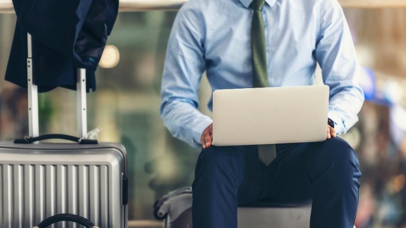 Người phụ nữ đang làm việc trên máy tính xách tay trên máy bay, minh họa việc sử dụng laptop trong chuyến bay.