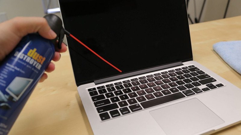 Sử dụng bình xịt khí nén để thổi bay bụi dưới các phím laptop