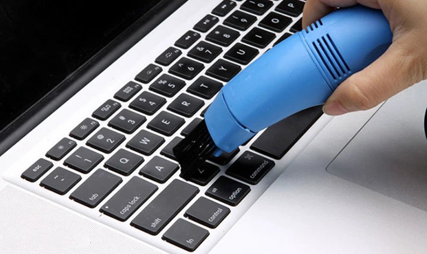 Sử dụng máy hút bụi mini chuyên dụng để hút sạch bụi trên bàn phím laptop Dell.