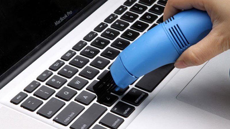 Vệ sinh bàn phím laptop bằng cọ, loại bỏ bụi bẩn và mảng bám, một bước quan trọng để tránh tình trạng bàn phím laptop bị đơ.