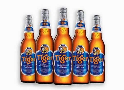 Bia Tiger của nước nào? Lịch sử và Sự phát triển toàn cầu Lon bia Tiger đặt trên nền gỗ